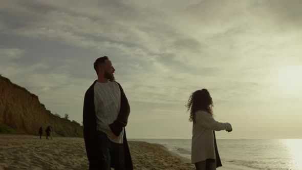 Playful Couple Walking Beach Sunset Sea Sky