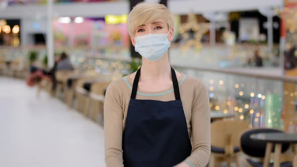 Mature Adult Middle Aged 40s Woman in Medical Mask Restaurant Cafe Worker Looking at Camera Crossing
