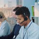 Close-up Shot of Smiling Mixed-race Man Taking Call in Busy Call Center - VideoHive Item for Sale