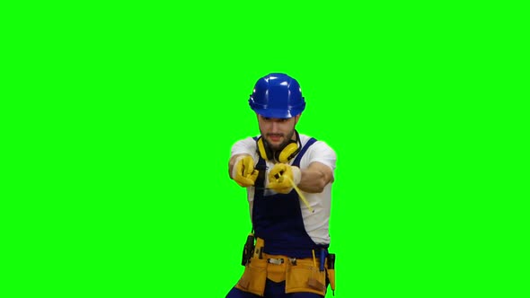 Builder Holds Two Roulettes in His Hands and Twists Them in Different Directions. Green Screen