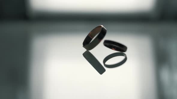 Gold wedding engagement rings rotate around their axis in slow motion