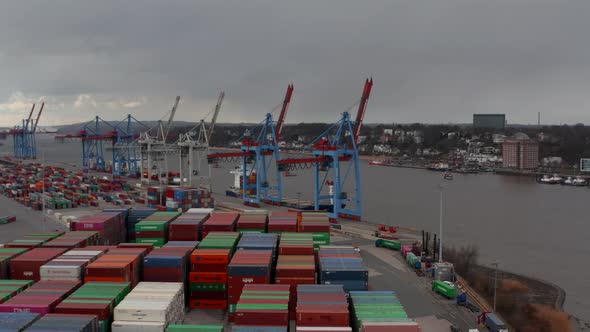 Low Aerial View of Cargo Cranes and Colorful Containers By the River in Hamburg Port