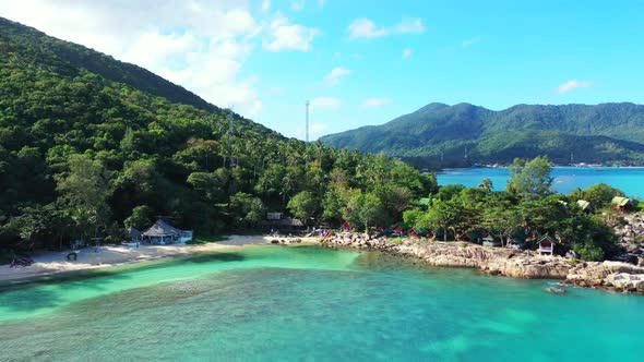 Aerial panorama of tropical coastline beach lifestyle by aqua blue ocean with white sandy background