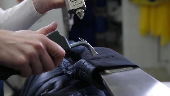 Worker's Hands Spraying Stain Remover Onto Sleeve