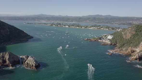 Aerial: Busy waterway of Knysna Heads and Lagoon on a sunny day