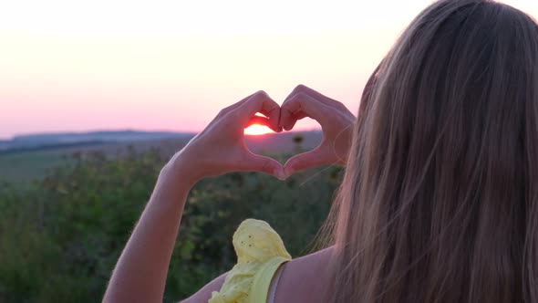 Close Up of Girl's Hands at Sunset with Heart