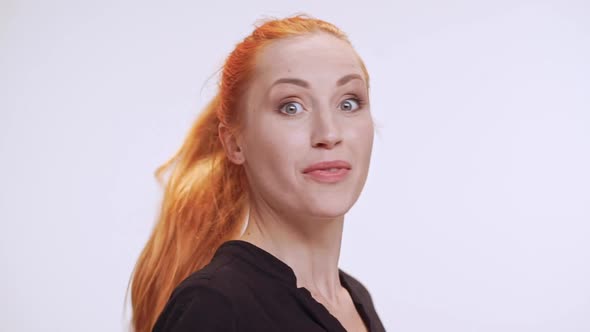 Young Caucasian Female with Colored Orange Hair Standing on White Background Then Noticing Someone