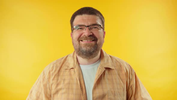 Optimistic 40s man sincerely laughing against orange background, happiness