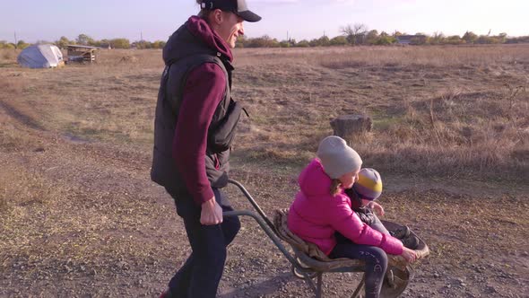 Man With Children In A Wheelbarrow