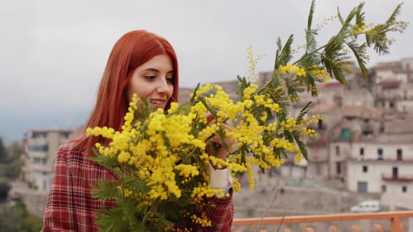 Red Hair Woman with Mimosa Flowers in Her Hand