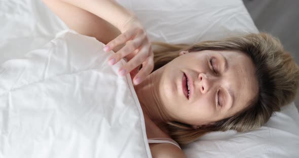 Woman Wakes Up Screaming While Lying on Bed Looking Under Covers