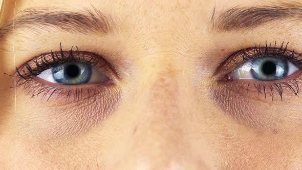 A Woman Opens Her Blue Eyes - Closeup