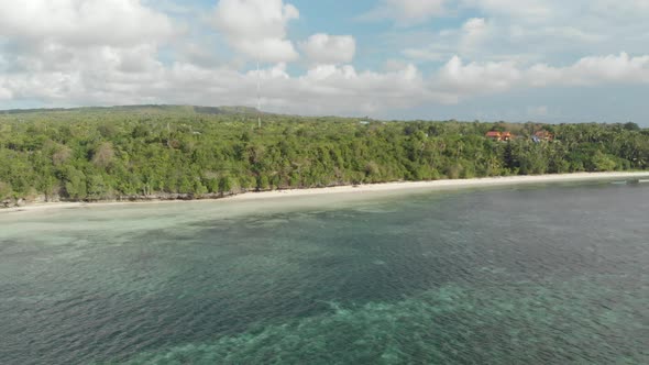 Aerial: Flying over tropical beach turquoise water coral reef Wakatobi Indonesia