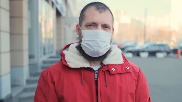 Bearded Man Wearing Protective Face Mask and Look at Camera Serious Pandemic Disease Virus. COVID-19