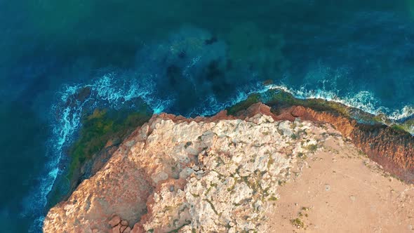 Aerial View. Down View Moving Forward Over Mediterranean Coastline Cliff Edge with White Sand and