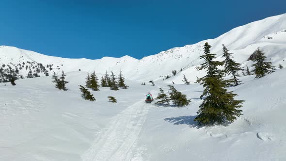Happy couple on a snowmobile high in the mountains 4 K