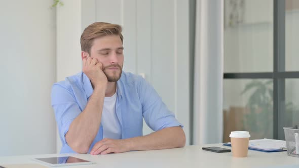 Young Creative Man Taking Nap While Sitting in Office