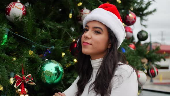 A happy young woman in a Santa hat celebrating Christmas time and the holiday season with a festive