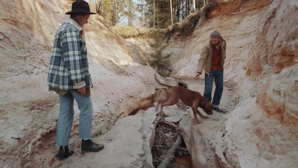 Young Couple and Dog Hiking in Canyon