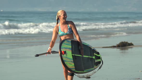 A woman sup stand-up paddleboard surfing at the beach