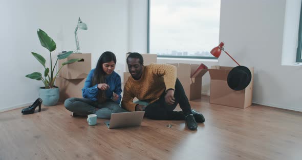 Couple sitting on the floor and shopping online