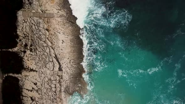 Aerial view of cliffs at Losinj coastline with agitated sea, Croatia.