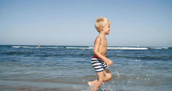 happy child running and smiling on the beach front to the sea on summer vacation
