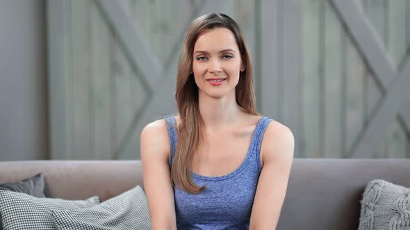 Portrait of Beautiful Young Domestic Woman Sitting on Couch
