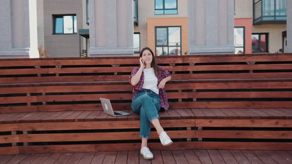 Girl Student Talking To a Friend Using a Mobile Phone