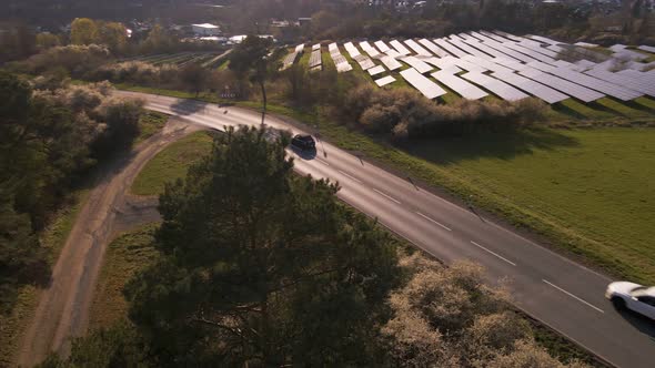 Fast cars driving past a solar power station in Germany. Aerial panning shot