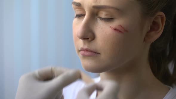 First Aid Measures, Doctor Putting Patch on Wounded Female Patient Face, Closeup
