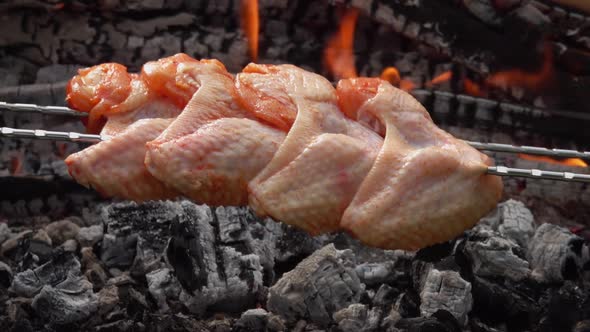 Raw Marinated Chicken Wings on the Skewers Are Placed Above the Burning Coals