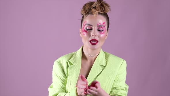 Young Beautiful Woman Professional Make Up Artist with Lipstick Marks Smile at Pink Background