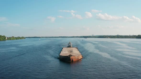 Aerial View of Towboat Tugging Barge with Grit Sailing Along River