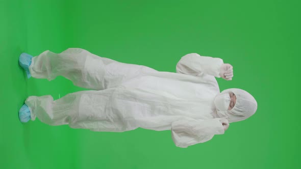 Asian Male Wear Protective Uniform PPE Wearing Medical Face Mask And Dancing In Green Screen Studio