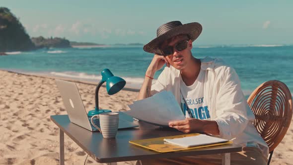 Young Millennial Remote Professional Works Away From the Office at the Beach