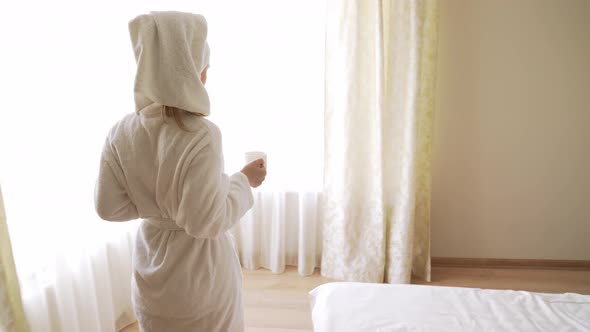 Woman Carrying Croissants and Cup of Hot Drink.