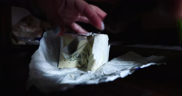 Girl Slicing Blue Cheese With A Knife