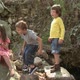 Girl sitting on rock and boys throwing stones - VideoHive Item for Sale
