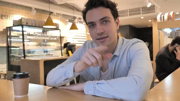 Portrait of Young Man Inviting Customers in Cafe