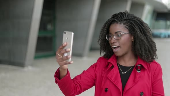 Woman Having Video Chat on Phone Outside, Behaving Emotionally