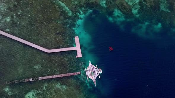 Raja Ampat islands Indonesia with divers exploring the reef below near the piers, Aerial top view ri