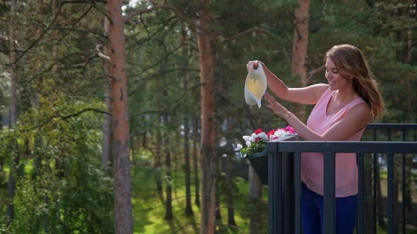 Woman Watering Flowers at Balcony Countryside Home