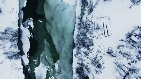 Aerial shot facing down showing tranquil icy lake in northern Sweden