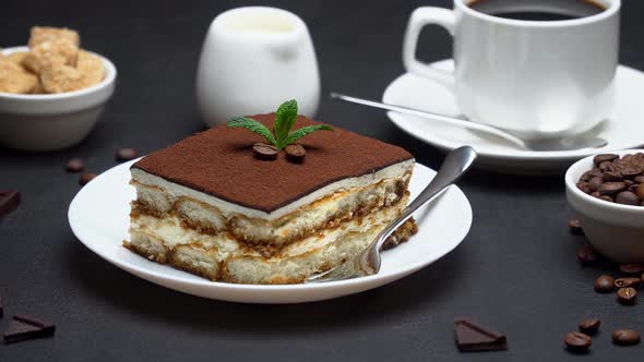 Portion of Traditional Italian Tiramisu dessert, cup of espresso coffee and coffee beans