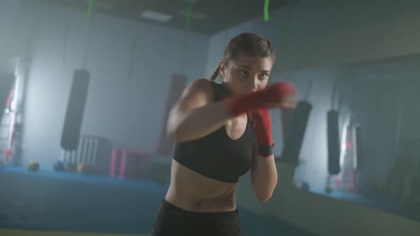 Caucasian Female Fighter Trains His Punches and Defense in the Boxing Gym the Girl Strikes Fast