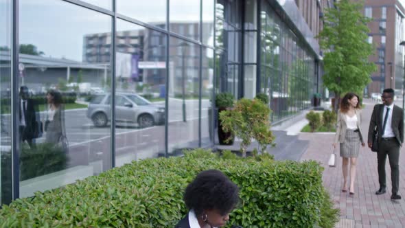 African Businesswoman Typing on Laptop and Drinking Coffee Outdoors