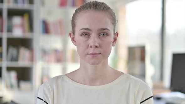 Portrait of Serious Young Woman Looking at Camera