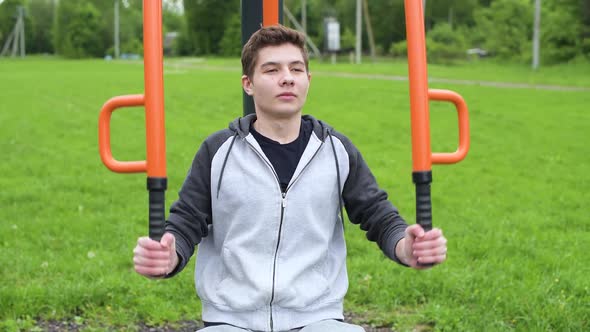 Front view of a training guy. Teenager doing sports on the training ground