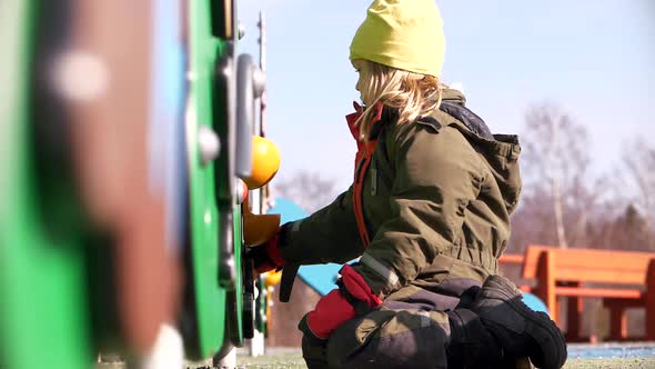 Alone caucasian girl playing at children's playground, low angle medium shot, Slow Motion